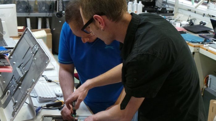 Two technicians working on a computer in the Creative IT workshop